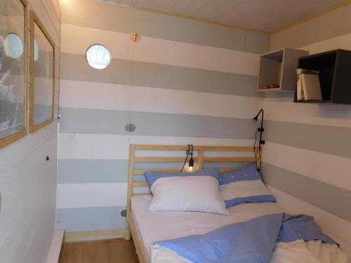 a bedroom with a bed with blue and white stripes at Hausbót na Vltavě in Hradišťko