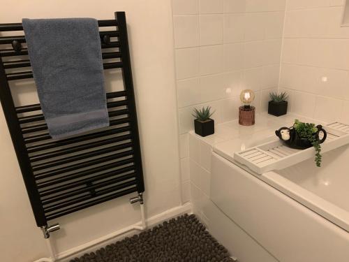 a bathroom with a bath tub with plants and a towel at The Velveteen Townhouse in Colchester