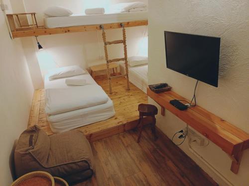 a small room with two bunk beds and a television at Sattahiptale Boutique Guesthouse & Hostel in Sattahip