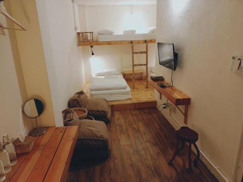 a small room with a bunk bed and a couch at Sattahiptale Boutique Guesthouse & Hostel in Sattahip