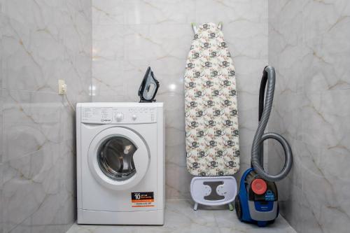 a washing machine with a tie next to a washer at Snow Time Eco Chalet in Gudauri