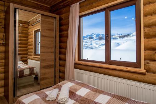 a bedroom with a window in a log cabin at Snow Time Eco Chalet in Gudauri