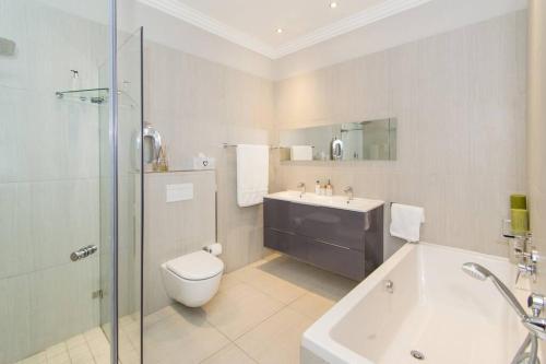a bathroom with a toilet and a sink and a shower at 9 Church View - No LoadShedding - Homely Apartment in Cape Town