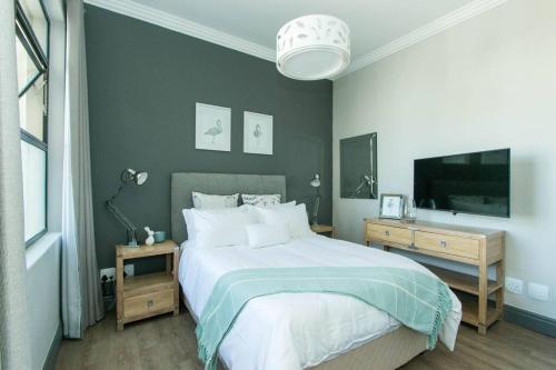 1 dormitorio con 1 cama grande y TV en 9 Church View - No LoadShedding - Homely Apartment, en Ciudad del Cabo