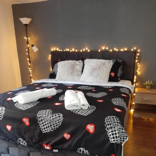 a bed with two white shoes on it with christmas lights at Apartman Živković in Leskovac