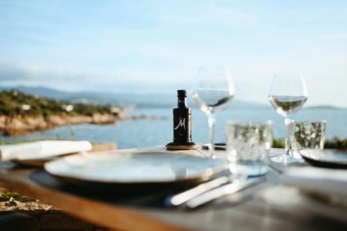 a table with glasses and a bottle of wine at Sofitel Golfe d'Ajaccio Thalassa Sea & Spa in Ajaccio