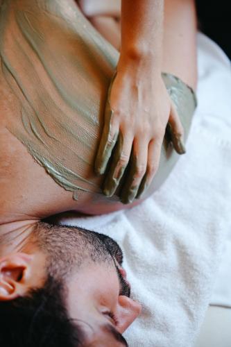 a man laying on his back on a towel at Sofitel Golfe d'Ajaccio Thalassa Sea & Spa in Ajaccio