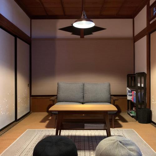 a living room with a bench and a ceiling fan at uminca ウミンカ in Numazu