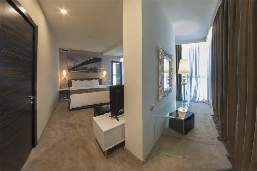 エレバンにあるOpera Suite Hotelのベッドとテレビがあるホテルの部屋