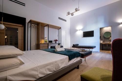 a bedroom with a bed and a desk and a television at Vespri Luxury Rooms & Suites in Palermo