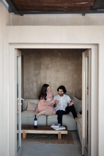 a man and a woman sitting on a couch at Santorini Sky, The Lodge in Pirgos
