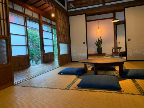 a room with a table and blue mats on the floor at uminca ウミンカ in Numazu