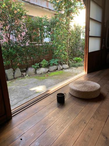 a door open to a porch with a wicker ottoman and a window at uminca ウミンカ in Numazu