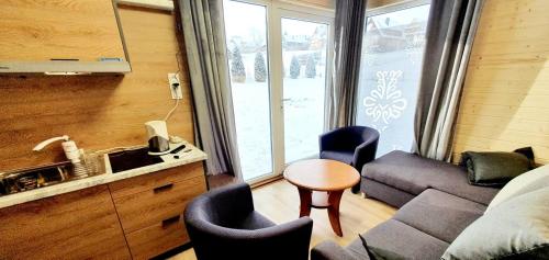 a living room with a couch and chairs and a table at ECO Domek z dużym ogrodem i widokiem in Murzasichle