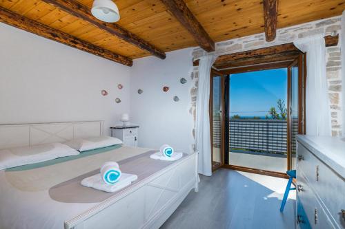a bedroom with a large bed and a balcony at Holiday Home Eufemia in Bale
