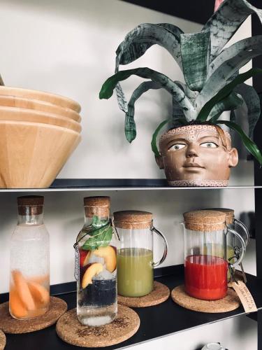 une étagère avec trois bocaux en verre et une plante dans l'établissement Harvey Suites Hotel & Residence, à Lido di Jesolo