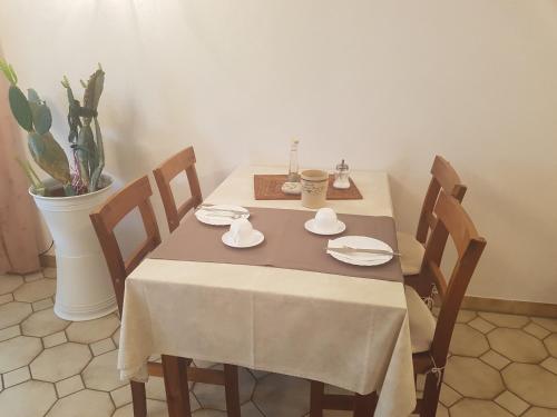 uma mesa de jantar com uma toalha de mesa branca e cadeiras em Pension Säntisblick em Meersburg