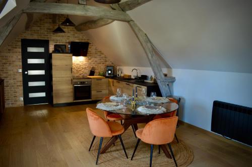 a dining room with a table with chairs and a kitchen at La Charmeraie Wellness & SPA in Lacroix-Saint-Ouen