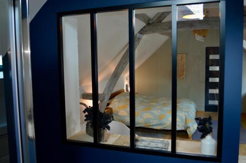 a mirror reflecting a bedroom with a bed in a room at La Charmeraie Wellness & SPA in Lacroix-Saint-Ouen