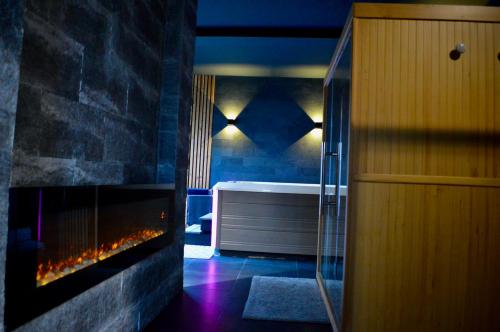 a bathroom with a bath tub and a fireplace at La Charmeraie Wellness & SPA in Lacroix-Saint-Ouen