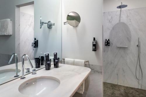a bathroom with a sink, mirror, and bathtub at One Shot Aliados Goldsmith 12 in Porto