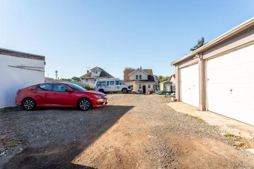 a red car parked on the side of a driveway at Best EWR Airport Studio-Hot Tub-Free Parking in Hillside