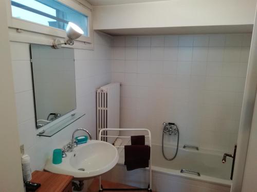 a white bathroom with a sink and a shower at Belgirate Casa Emilia in Belgirate