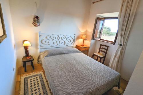 a bedroom with a bed in a room with a window at Herdade do Marmeleiro in Bicos