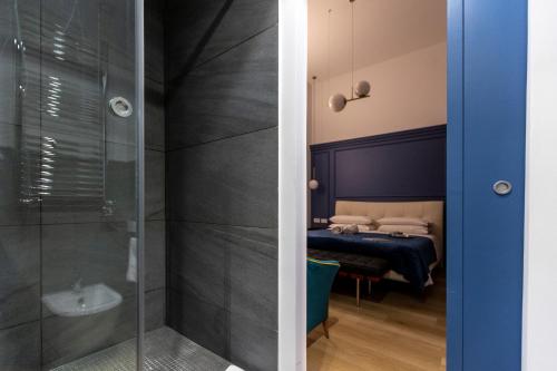 a bathroom with a shower and a room with a bed at Vespri Luxury Rooms & Suites in Palermo