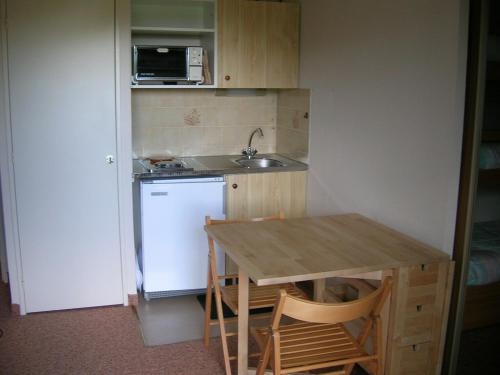 una cucina con tavolo, lavandino e frigorifero di LELEX, MONTS JURA, LES ETALES 26 a Lélex
