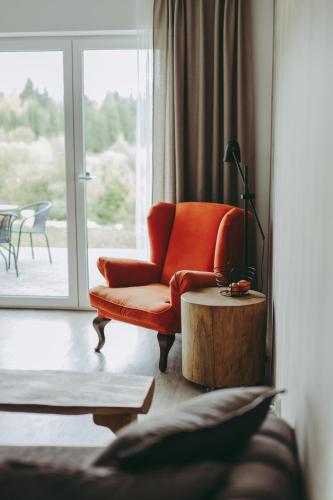 a living room with an orange chair and a table at Wilczarz in Duszniki Zdrój
