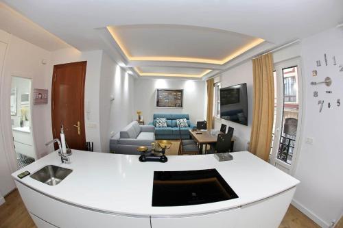 eine Küche und ein Wohnzimmer mit einer weißen Arbeitsplatte in der Unterkunft Piso Reformado a 2 Min del Casco Viejo Con Garaje Gratis in Bilbao