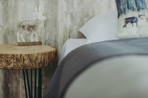 a bedroom with a bed and a table with a night stand at Wilczarz in Duszniki Zdrój