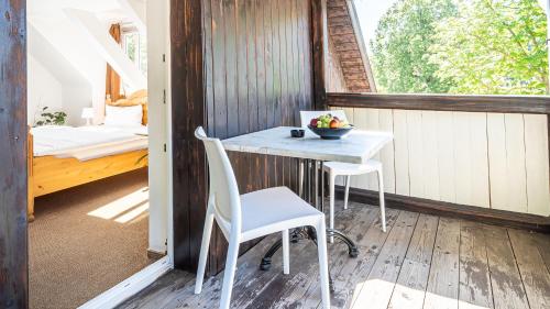 a porch with a table and two chairs and a bed at Murphy's Zimmer und Apartments in Bad Suderode