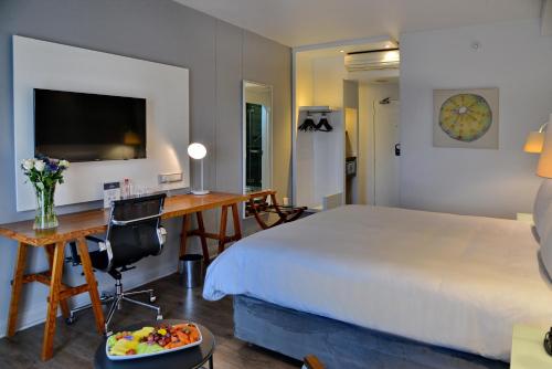 a bedroom with a bed and a desk with a computer at ANEW Hotel Roodepoort Johannesburg in Roodepoort
