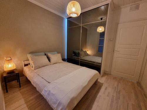 - une chambre avec un grand lit et un miroir dans l'établissement Apartment Louna, à Lahti