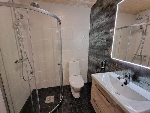 a bathroom with a shower and a toilet and a sink at Apartment Louna in Lahti