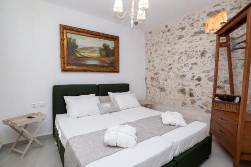 a bedroom with two beds and a painting on the wall at Yiayia's Place in Vathiakón