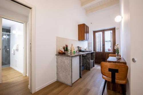 Vespri Apartments في باليرمو: مطبخ بجدران بيضاء وقمة كونتر