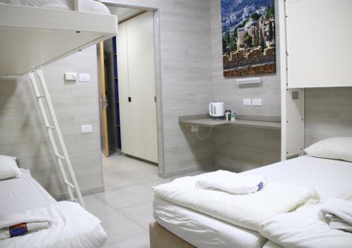 a hospital room with two beds and a sink at HI Rabin - Jerusalem Hostel in Jerusalem