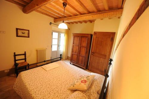 a bedroom with a bed and a window at Piccolo Borgo Gagnoni in Sinalunga