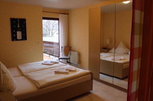 Schlafzimmer mit einem Bett und einem Spiegel sowie einem Balkon in der Unterkunft Weingut Gorges-Reinhard in Wintrich