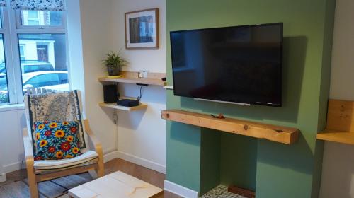 a living room with a flat screen tv on a wall at Portallo Peace: a sanctuary in the city. in Belfast