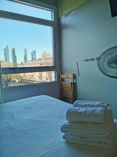 a bedroom with a bed and a large window at La Posada de El Chaflán in Madrid