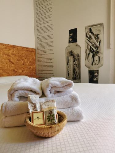 a pile of towels on a bed with a basket at La Posada de El Chaflán in Madrid