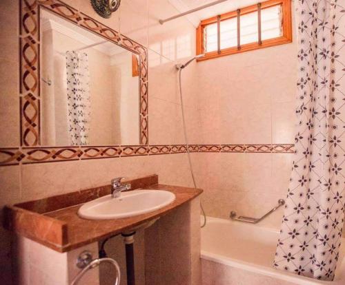 łazienka z umywalką, wanną i lustrem w obiekcie Apartment Avenida Puig w Aronie