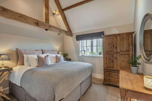 a bedroom with a large bed and a window at Pheasant Cottage in Tarporley