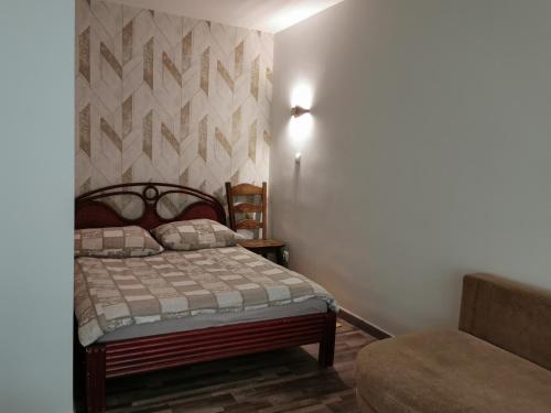 een slaapkamer met een bed en een muur bij Velvet Trojdena in Warschau