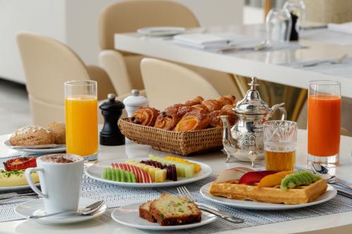 a table with plates of breakfast foods and drinks at Marchica Lagoon Resort in Nador