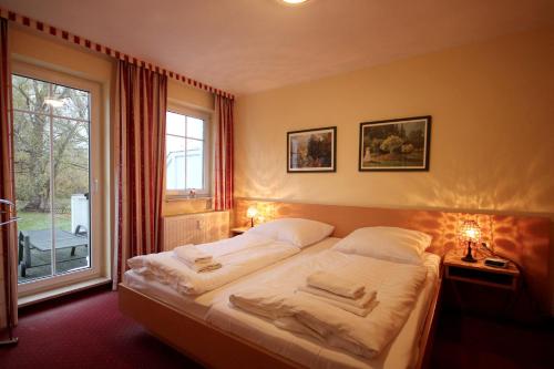 ein Schlafzimmer mit zwei Betten und einem großen Fenster in der Unterkunft Schlösschen am Schmachter See by Rujana in Binz